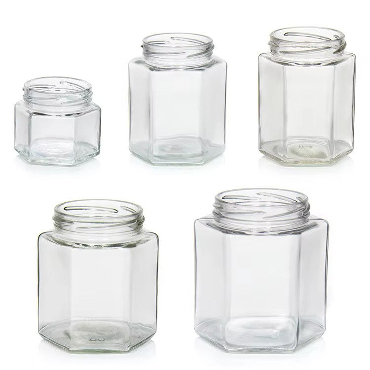Υψηλής ποιότητας 2oz 3oz Διαφανή στρογγυλή διαφανή γυάλινα βάζα με μέλι για μέλι με χρωματικά καπάκια